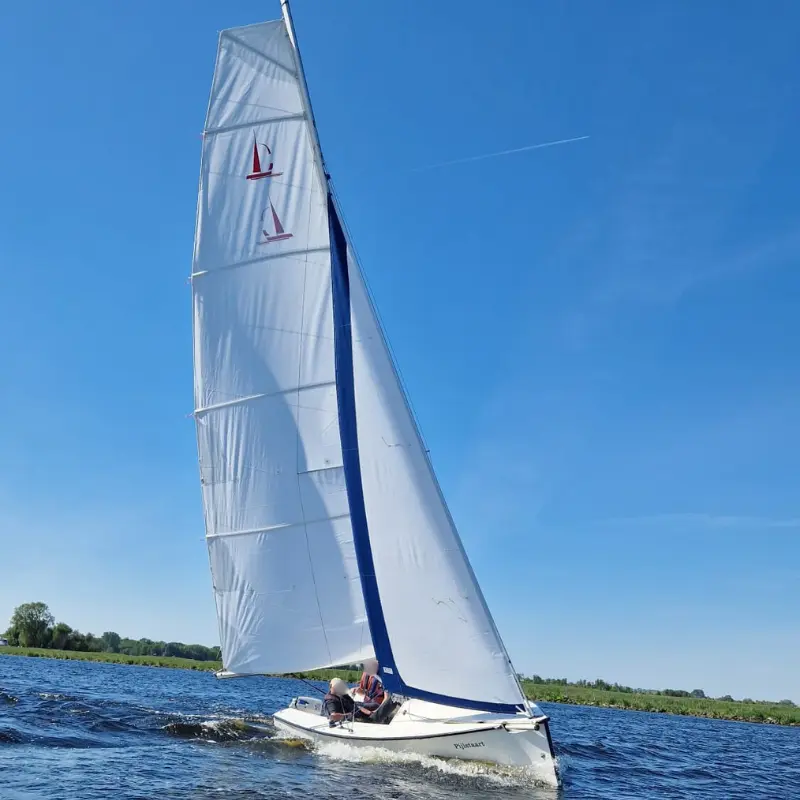 Falcon Racing bei Sonnenschein mit weiß-blauem Großsegel